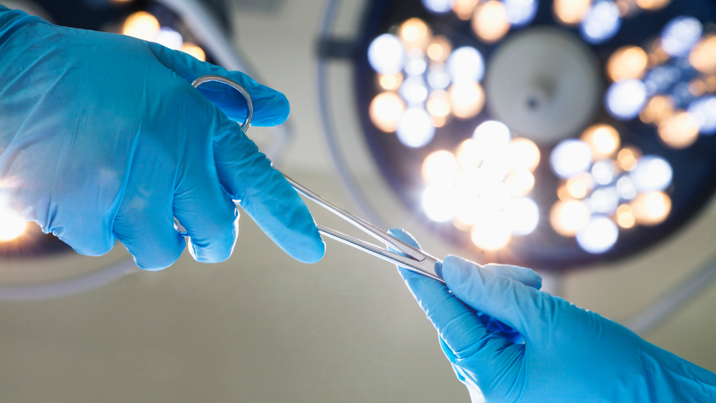 Surgeons Passing Surgical Instrument
